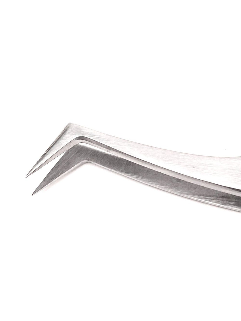 Close-up of stainless steel L tweezer on white background