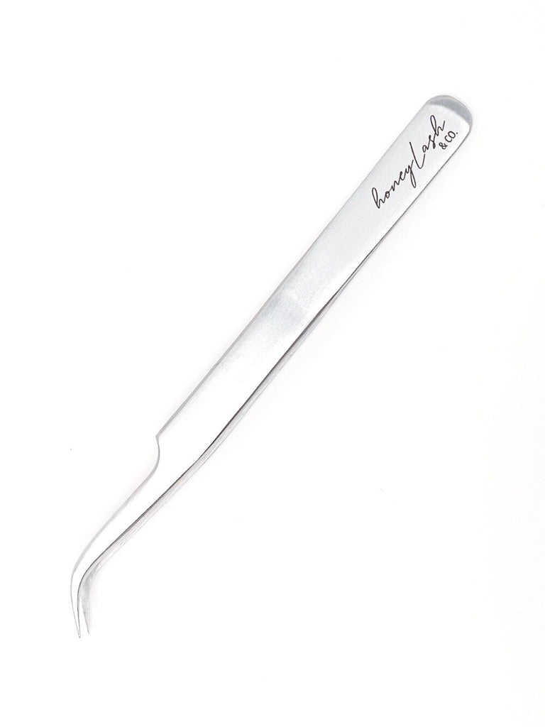 Close-up of an isolation curved tweezer on a clean, white background, ideal for precise eyelash extension application